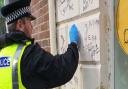 Police officers clean away graffiti