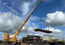 One of the ix steel bridge deck beams being lifted into place