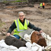 A volunteer shows off the Roman heads discovered in Carlisle.