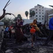 Palestinians carry belongings as they leave al-Ahli hospital, which they were using as a shelter, in Gaza City