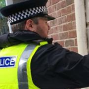 Police officers clean away graffiti