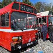 Volunteers stand next to a Leyland National Bus