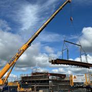 One of the ix steel bridge deck beams being lifted into place