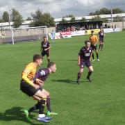 IN THE THICK OF IT: Reds’ new signing Matty Clarke, yellow, tussles with home defender Luke Denson 
Steve DURHAM