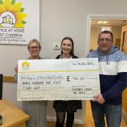 Hospice at Home staff are presented with the cheque