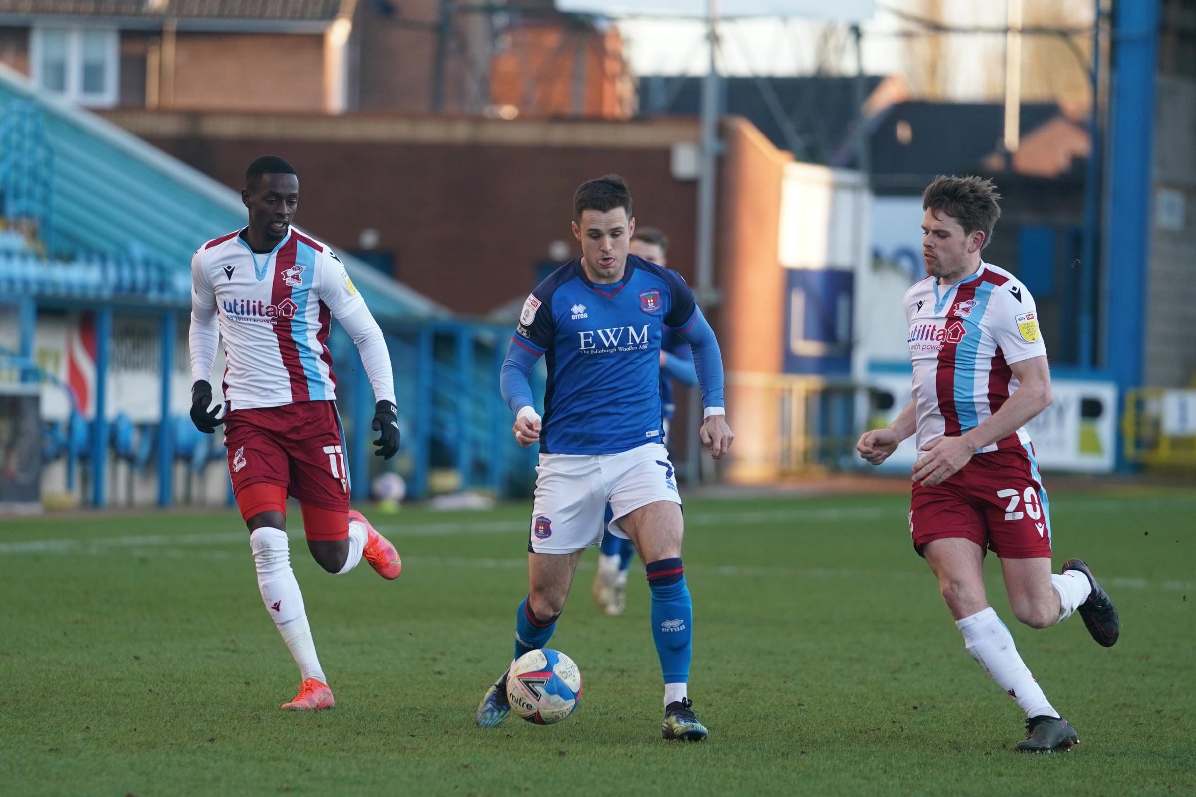 SQUEEZED: Joe Riley comes under pressure on the ball for Carlisle in the first half
