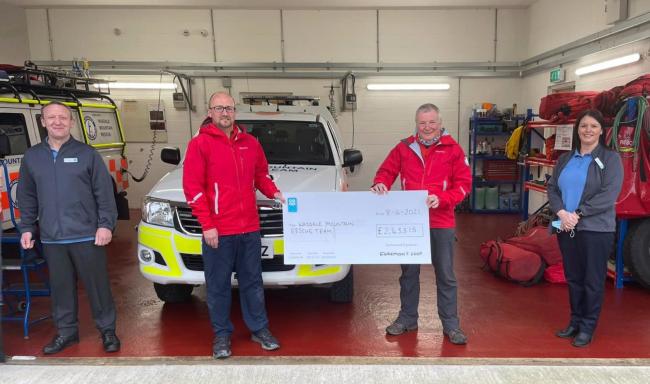 Mountain rescue volunteers are presented with a cheque from Egremont Co-op staff