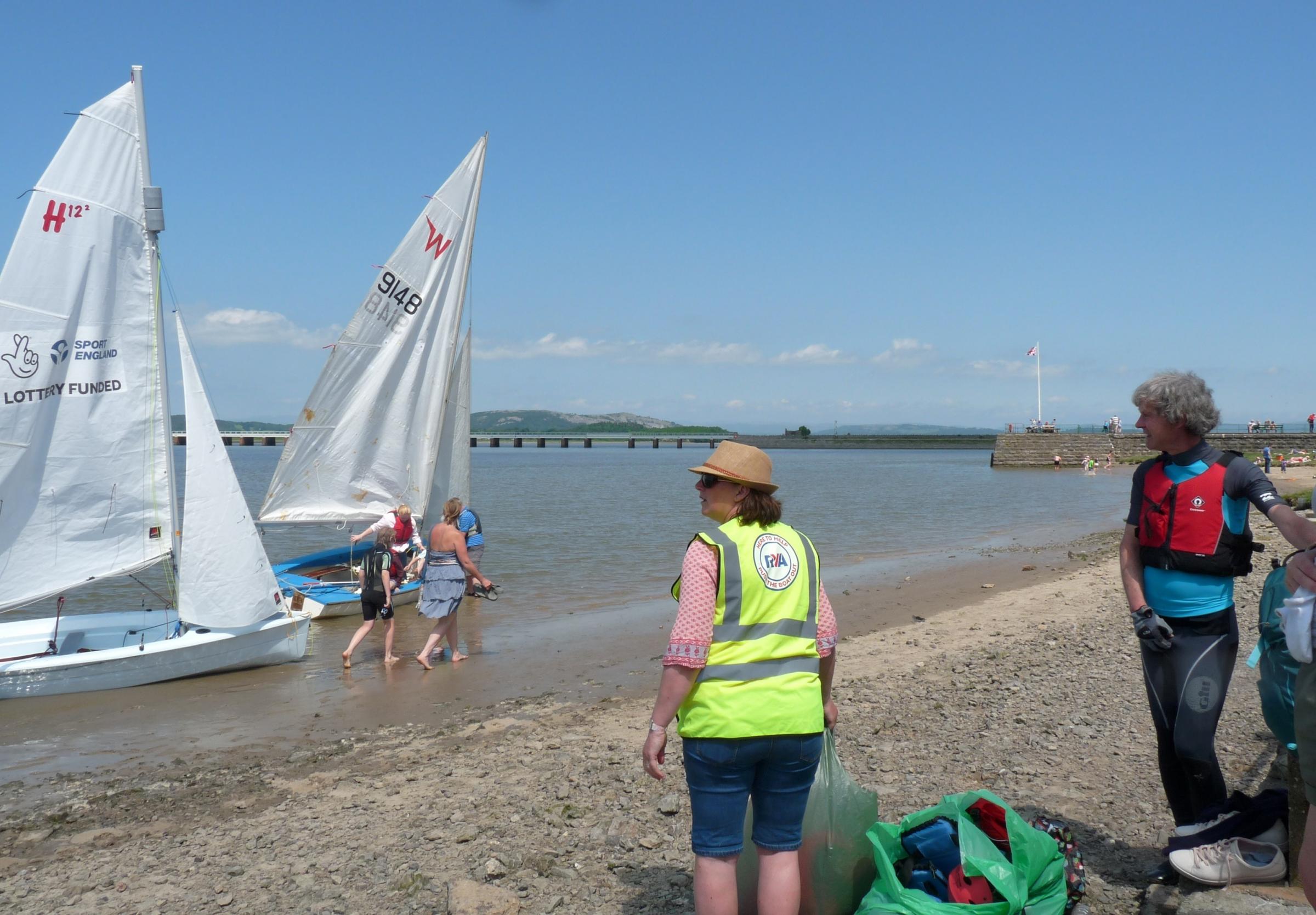 Arnside Sailing Club members turning boats on the beach tide