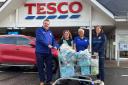 Tesco staff handing over the period product packs