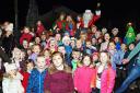 LET THERE BE LIGHTS: Santa and his elves are joined by the children of St Bees as he switches on the village's Christmas tree lights in 2015