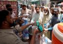 Volunteers provided lime sugar water to people at a camp in Karachi (Fareed Khan/AP)