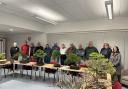 Members of the Carlisle Bonsai club pose proudly with their Bonsai trees at Harraby Community Centre