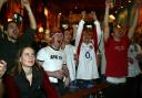 England rugby fans cheer their team at a pub.