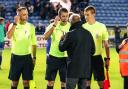 Paul Simpson speaks to ref Scott Simpson and his assistants after the game