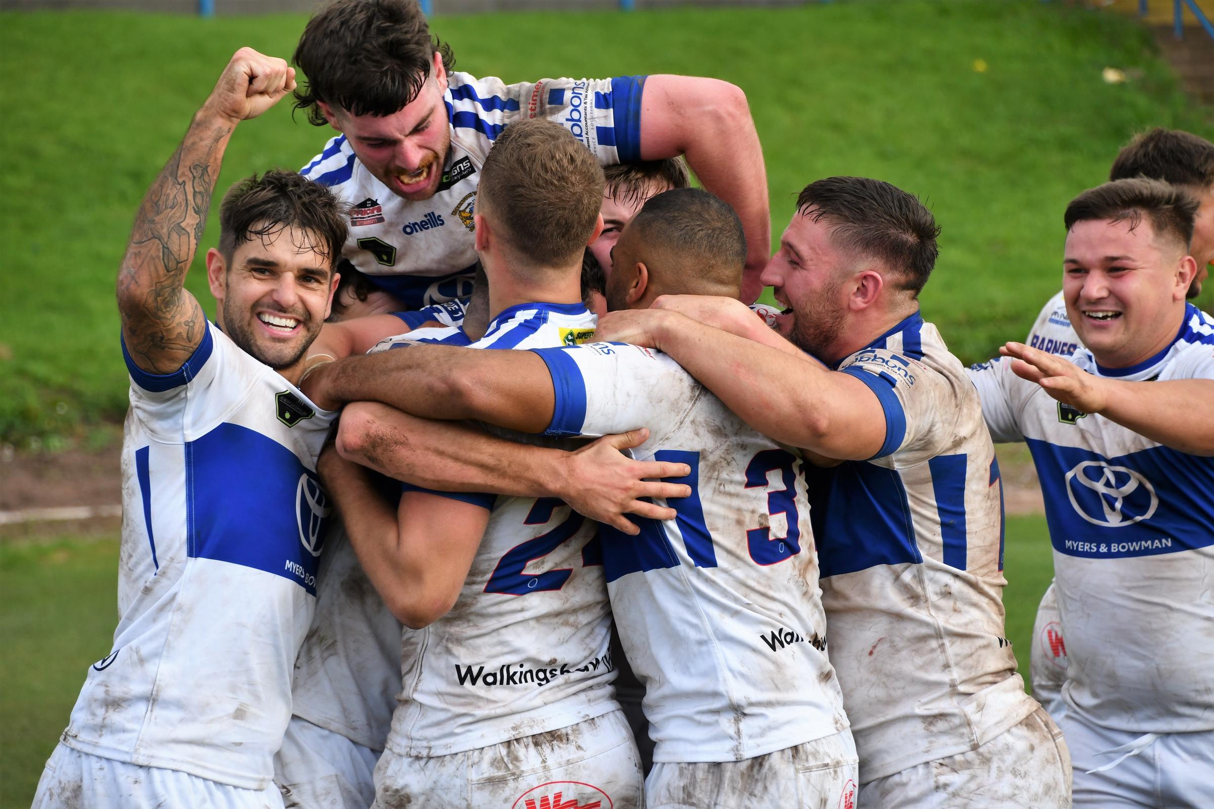 Workington Town players celebrate after securing promotion back to the Championship for 2022. Picture: Ben Challis