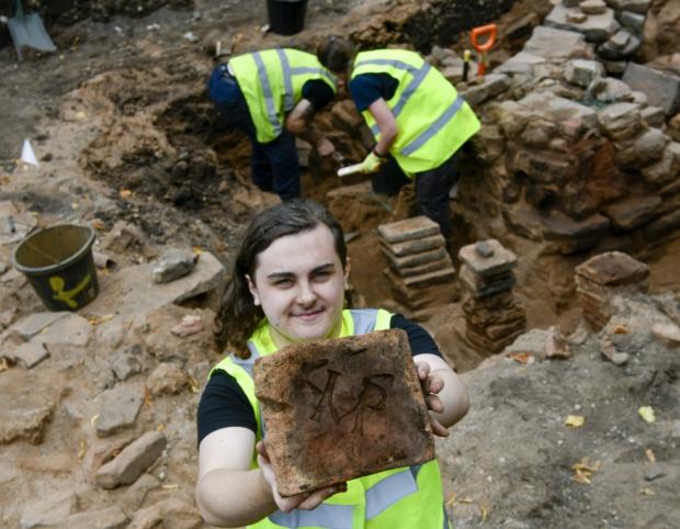 News and Star: Imperial: A volunteer displays one of the 'Imperial stamped' Roman tiles from the site. Photo: Stuart Walker Photography.