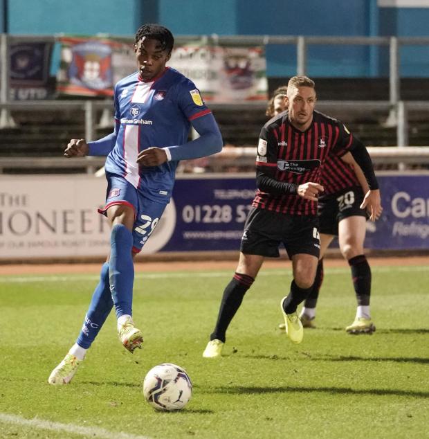 News and Star: Tyrese Omotoye aims a pass as Gary Liddle, right, gives chase