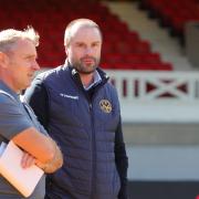 Darren Kelly, right, pictured speaking to Paul Simpson at Newport's home game against Carlisle last season