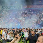 Scenes from the pitch invasion after the Bradford play-off game at Brunton Park