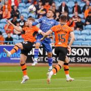 Carlisle's Alfie McCalmont jumps between two Dundee United opponents