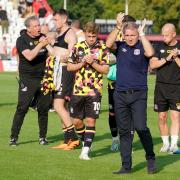 Paul Simpson and his staff and players acknowledge United's fans at Stevenage