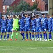 Carlisle players stand for a minute's silence for Lincoln club stalwart Doreen Ashton before the game
