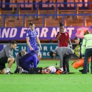 Sam Collins receives treatment before being stretchered off