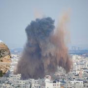 Smoke rises from an explosion caused by an Israeli airstrike in the Gaza Strip with inset of Paul Calvert