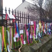 A symbol of hope, the loudfence ribbons and messages displayed outside St Peter's Church, Kirkbampton.
