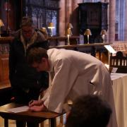 The Rt Rev Rob Saner-Haigh, watched by Sandra Bischler, signing the new partnership agreement