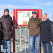Members of the Castletown Community Action Group with the reinstated community notice board