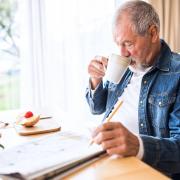 A generic stock photo of an older man doing crosswords at home. See PA Feature TOPICAL Wellbeing Older Relatives. Picture credit should read: iStock/PA. WARNING: This picture must only be used to accompany PA Feature TOPICAL Wellbeing Older Relatives.